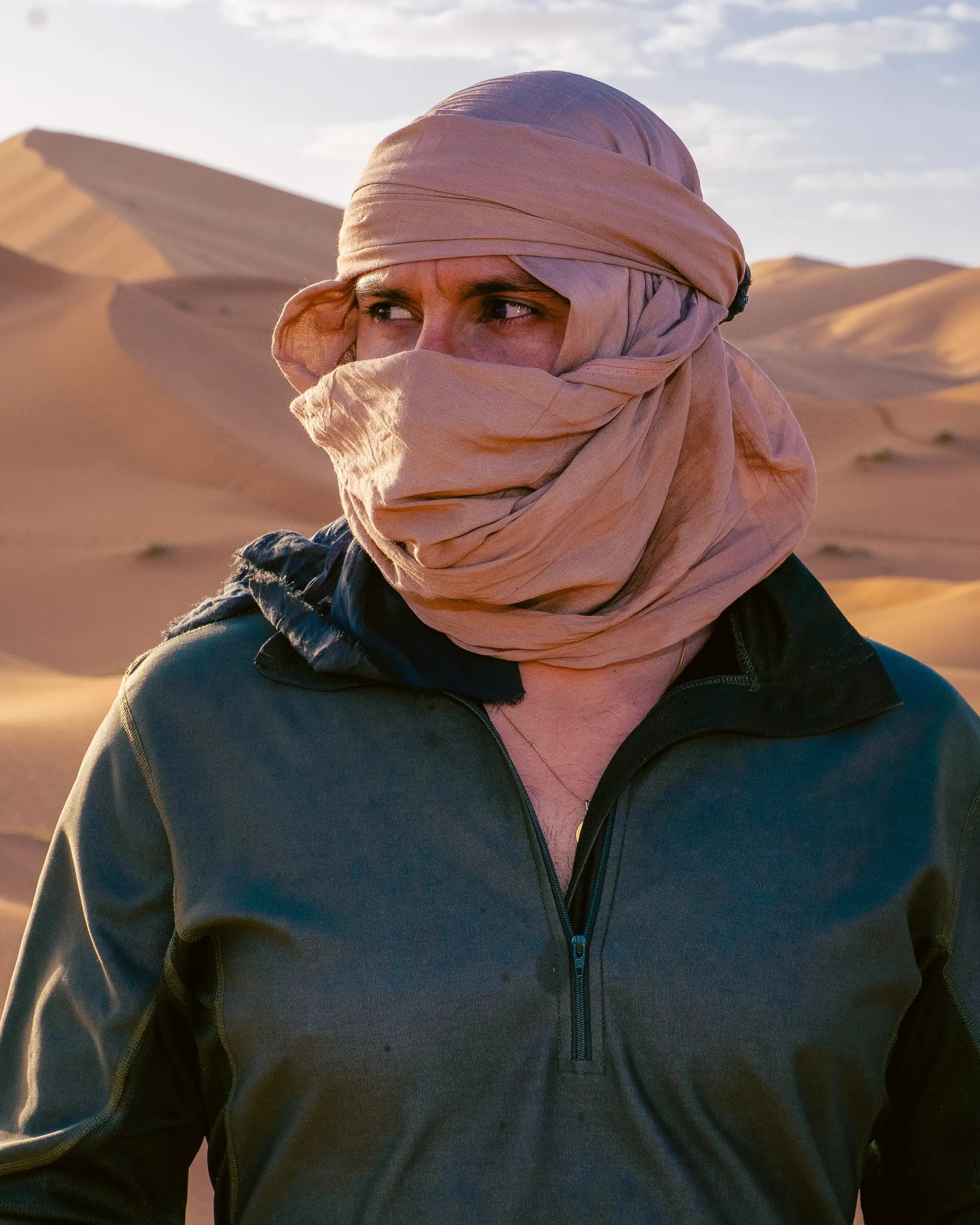 A Touareg guide, his face wrapped in a chèche, in the dunes of Erg Chebbi